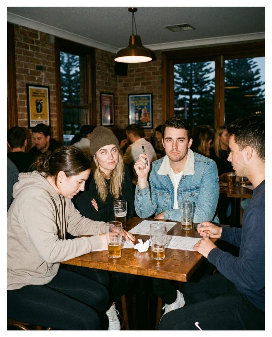 A trivia team huddled over an answer sheet at a pub
