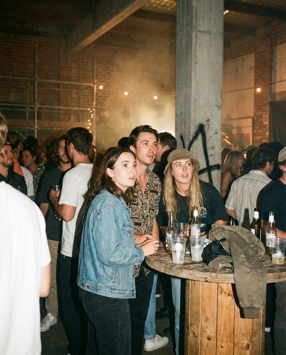 A crowd dancing at a warehouse party caught by a camera flash